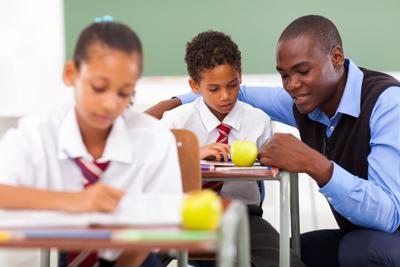 Educator assisting a student in the classroom.